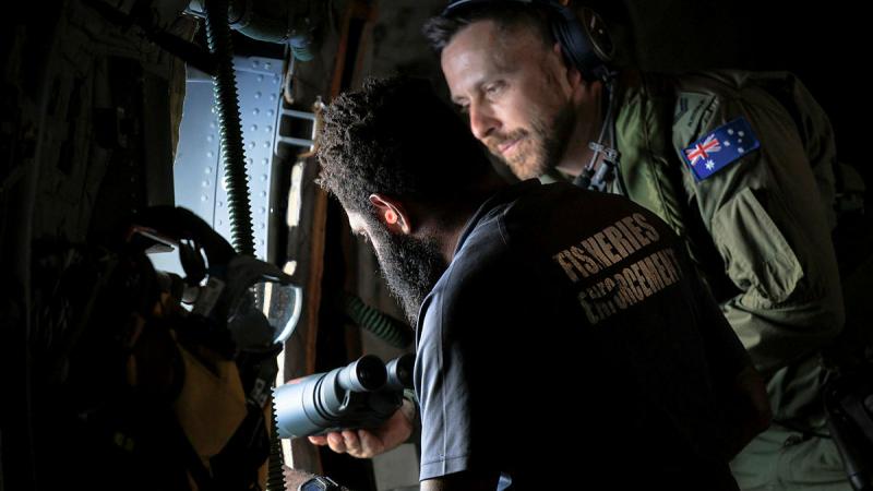 Corporal Peter Fowler assists Jino Suaki from the Pacific Island Forum Fisheries Agency with conducting surveillance operations for illegal maritime activity around the islands of Vanuatu during Operation Solania. 