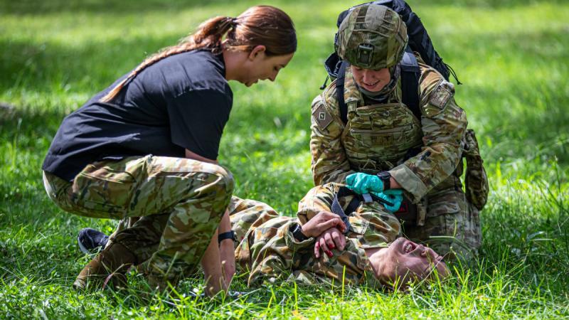 Australian Army medic Private Sarinda Mills (left) is an observer mentor overseeing emergency medical care provided to a simulated casualty at the point of injury during Exercise Viper Walk 2024.