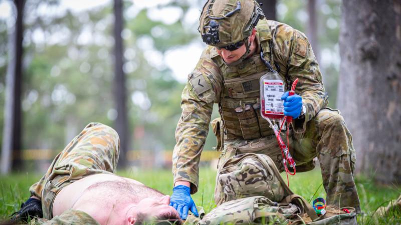 An Australian Army medic from 2nd Health Battalion provides blood to a simulated casualty at the point of injury during Exercise Viper Walk 2024.