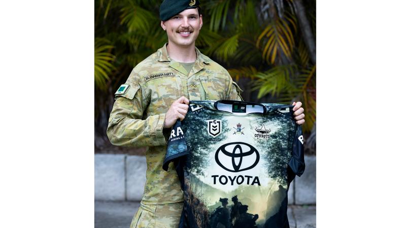 Lance Corporal Riley Blennerhassett at HMAS Kuttabul, Sydney, with the North Queensland Cowboys Anzac Day 2024 jersey – which features an image he took during Exercise Brolga Run 2023. 