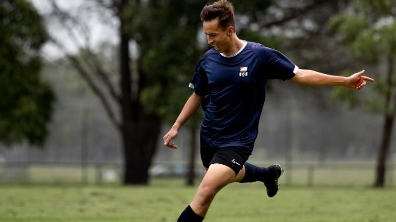 Navy sailor Leading Seaman Matthew Parry represents his ADF soccer team as he kicks a ball at HMAS Albatross.