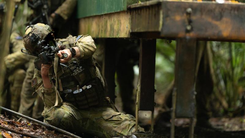 An Australian Army soldier from the 8th/9th Battalion, the Royal Australian Regiment, helps clear a village during Exercise Regional Warfighter in Tully, Queensland. 