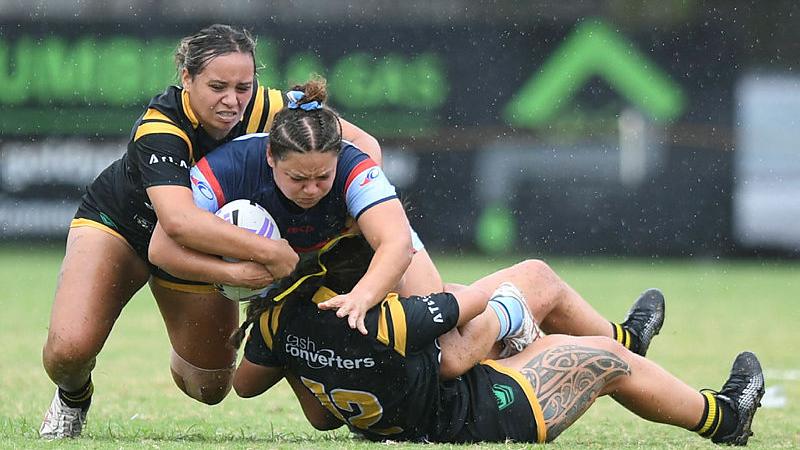 Australian Army soldier Private Mikaela Trbojevich (centre) is tackled during her match against Western Australia.