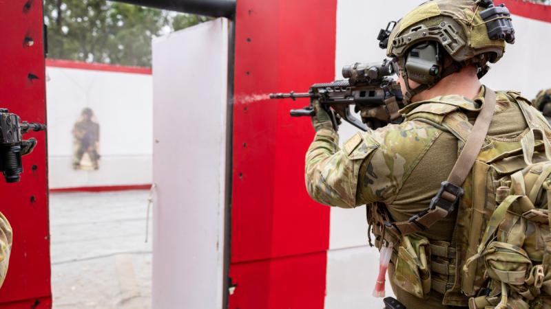 An Australian Army soldier fires at a target in a deployable austere shoot house facility at Greenbank Training Area.