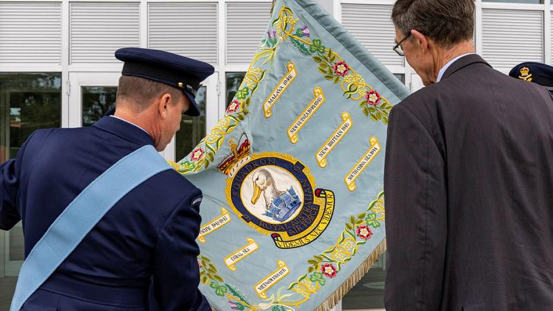 9 Squadron Association patron and former Commanding Officer, Air Chief Marshal Angus Houston is shown the Squadron Standard.