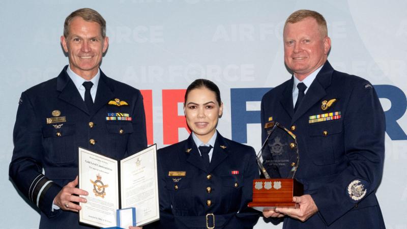 Chief of Air Force Air Marshal Robert Chipman, left and Warrant Officer of the Air Force Ralph Clifton, right, present the Enlisted Aviator of the Year Award to Corporal Kbora Ali. 