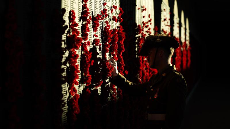 Trooper Kane Boland places a poppy on the Roll of Honour at the Australian War Memorial during the lead-up to Anzac Day.