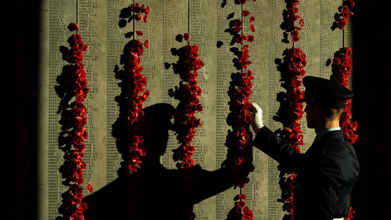 Aircraftman Jordan McGrath, of Australia's Federation Guard, places a poppy on the Roll of Honour at the Australian War Memorial during the lead-up to Anzac Day 2024.
