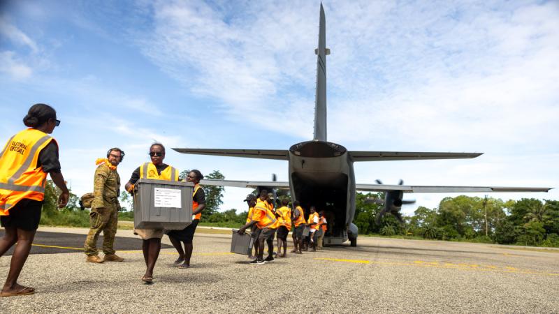 Air Force aviators deployed on Operation Lilia observe members of the Solomon Islands Electoral Commission unloading poll boxes from a RAAF C-27J Spartan in the Solomon Islands.
