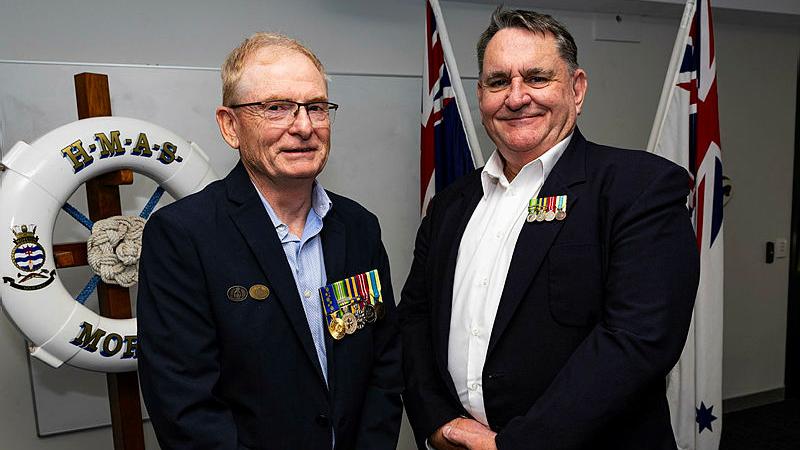 Michael Apperley and Paul Longley meet after many years at their unit citation ceremony in HMAS Moreton. 