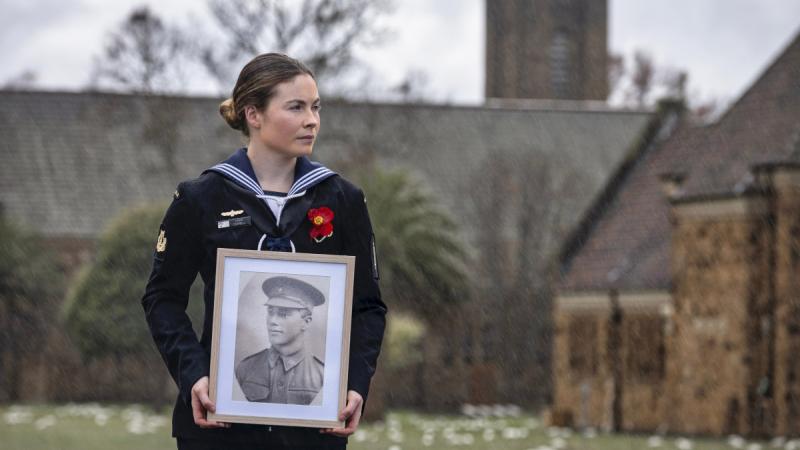 Navy musician Able Seaman Laura Campbell with a portrait of her great, great Grandfather's brother, Leonard Louis Webb, who served in World War 1 at Gallipoli. 
