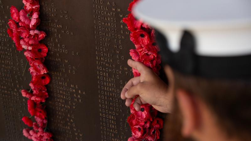 Able Seaman Mitchell Rigney points at Private Rufus Gordon Rigney's name on the roll of honour at the Australian war memorial in Canberra.