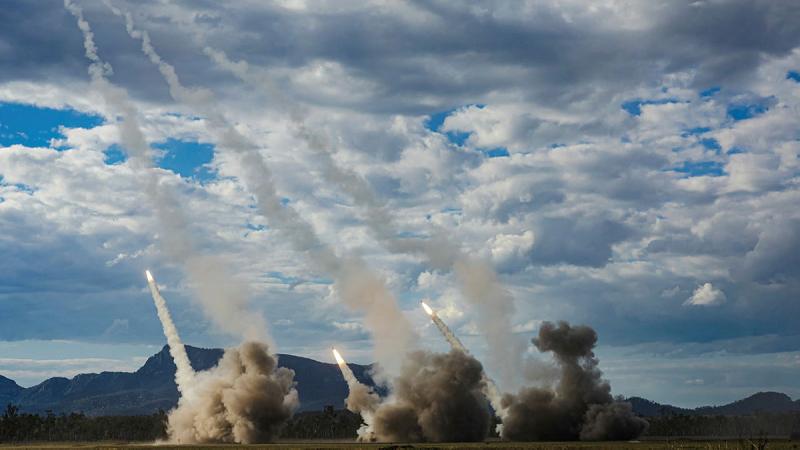 High Mobility Artillery Rocket Systems firing in unison.