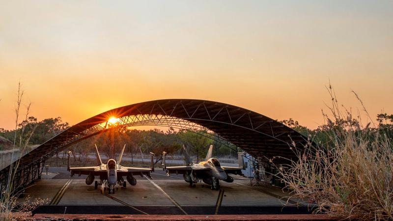 Super Hornets in a hangar at RAAF Base Tindal at sunset.