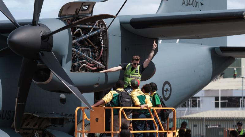 Leading Aircraftman Joshua Row shows the students from Port Moresby Technical College an engine bay of a C-27J Spartan aircraft at Port Moresby airport, Papua New Guinea, during the Defence Pacific Air Program.