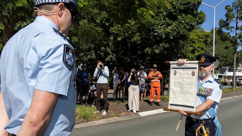 95 Wing, Wing Warrant Officer, Korey McGregor presents a scroll, authorising the freedom of entry for 95 Wing to Acting Inspector Michael Morier of the Queensland Police Service.
