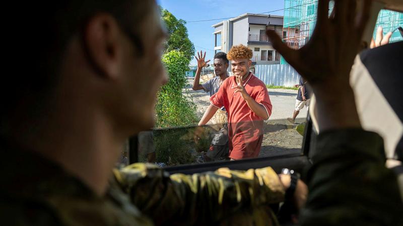 An Australian Army soldier waves at Solomon Island locals during a community engagement visit around Honiara, Solomon Islands. 