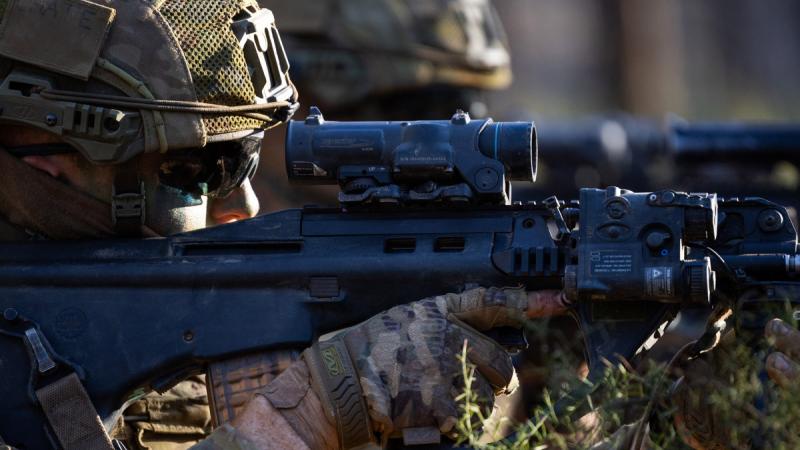 A soldier from the School of Infantry takes aim from the defensive position at the Singleton Military Area, NSW, during Exercise Hardcorps. 