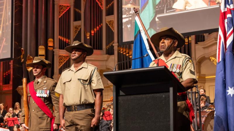 Australian Army soldier Sergeant Clayford Lui, right, of 51st Battalion, Far North Queensland Regiment, addresses the audience about the World War 2 service by Torres Strait Islanders during the Lest We Forget Anzac Day 2024 Tribute Concert at Sydney Town Hall. Left to right: Sergeant Lachlan Youll, Headquarters 2nd (Australian) Division; Private Letrell Uta, 51st Battalion, Far North Queensland Regiment; and Sergeant Clayford Lui. 