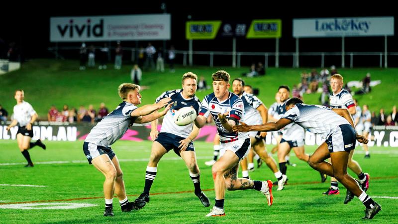 Able Seaman Clearance Diver Jamie Perry runs the ball as the Navy Tridents take on the Royal Navy in an NRL Anzac Round curtain raiser game at 4 Pines Park in Manly.