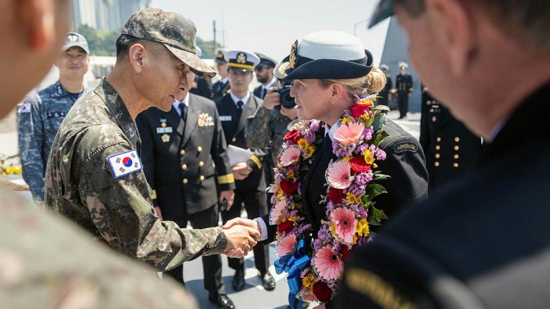 Republic of Korea Navy Commander Dae-Joong Lee shakes hands with Commanding Officer HMAS Hobart, Commander Tina Brown, during an official welcome meeting in Busan, Republic of Korea as part of a regional presence deployment. 
