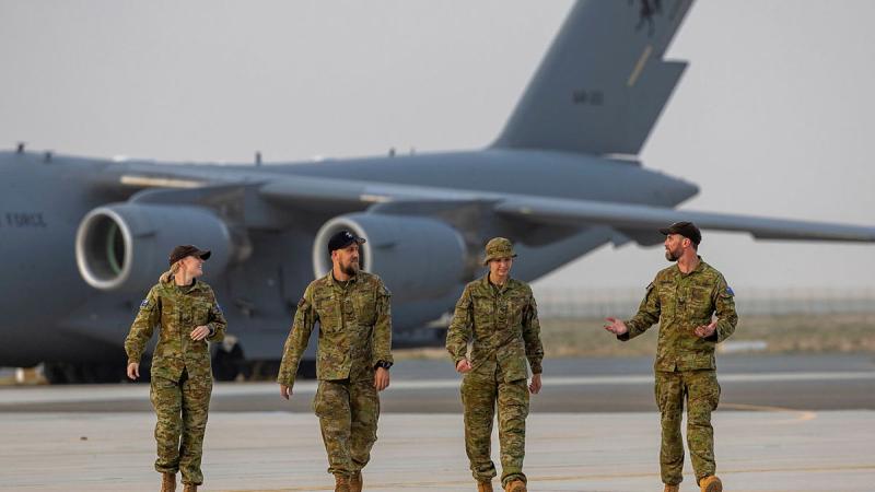 RAAF 36 Squadron personnel walk from a C-17 Globemaster towards Hurley’s Hangar after arriving at Australia’s main operating base in the Middle East Region. 
