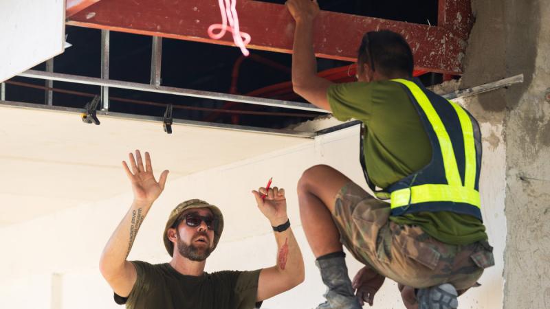 RAAF carpenter Leading Aircraftman Matthew Kunde and a member of the Armed Forces of the Philippines plan the fitting of plaster to the roof of a newly constructed classroom at St Augustine School, San Fernando, during Exercise Balikatan in the Philippines. 