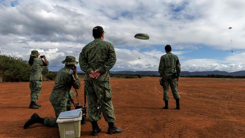 Personnel from the 3rd Singapore Armed Forces Transport Battalion assist with an air drop at the Londonderry drop zone during the Republic of Singapore Air Force C-130 Training Detachment 2024 in Australia.