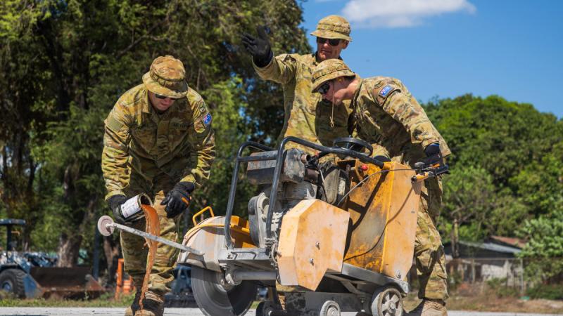 Royal Australian Air Force plumbers Corporal Anthony Holmes, left, and Leading Aircraftman Matthew Park, and plant operator Leading Aircraftman Ryan Wilson operate a concrete-cutting saw at Basa Air Base, Philippines, during Exercise Balikatan.