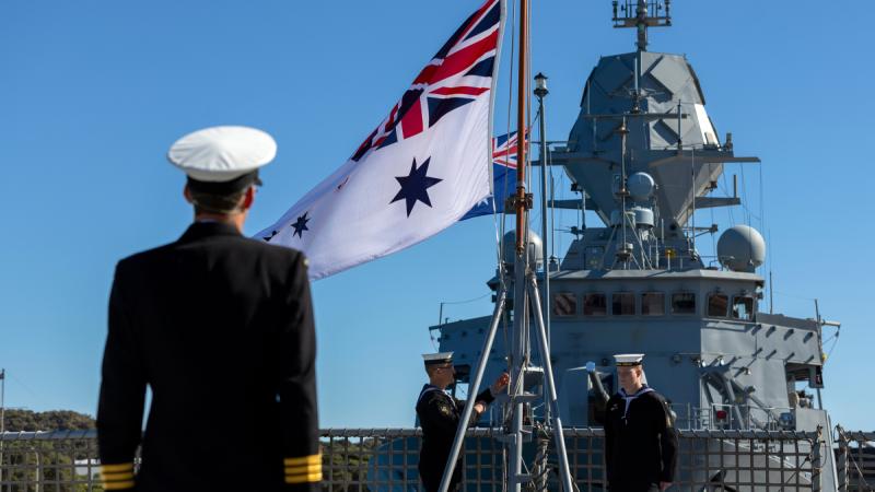 The Ensign Party lowers the Australian White Ensign for the last time on the flight deck of HMAS Anzac during the decommissioning ceremony held at HMAS Stirling, Western Australia.