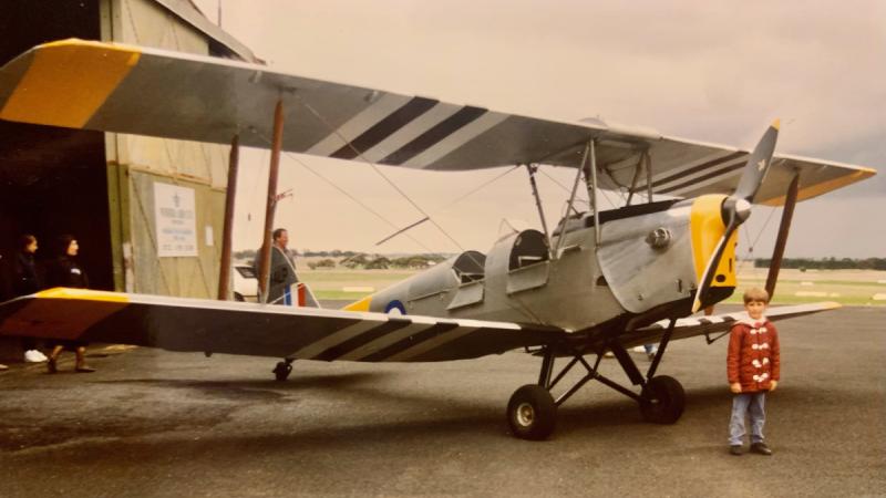 Eight-year-old Squadron Leader Samuel da Graca Costa in front of the Tiger Moth he flew in at Nhill.