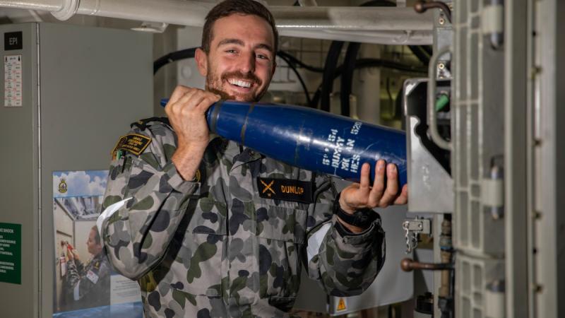 Leading Seaman Electronics Technician Stephen Dunlop loads HMAS Brisbane's five inch gun as she sails off the coast of New South Wales, Australia.
