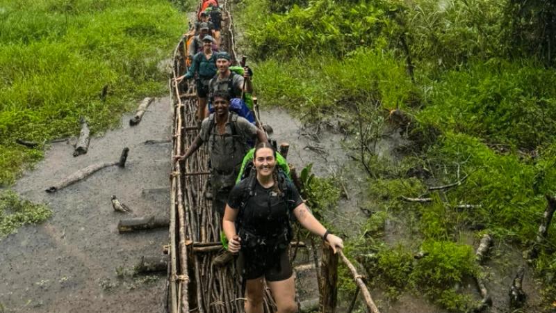 Royal Australian Navy HMAS Cairns sailors cross a swamp marsh on their way to Agulogo on day three along the Kokoda Track.