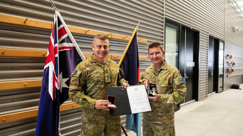 Major Stephen Ware, right, is presented with two Federation Stars by Major General Gregory Novak at Gallipoli barracks, Brisbane. 