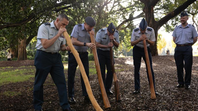 Attendees of the Five Eyes Air Force Interoperability Council National Directors meeting learn to play the Yidaki (Didgeridoo) in Hyde Park, Sydney.