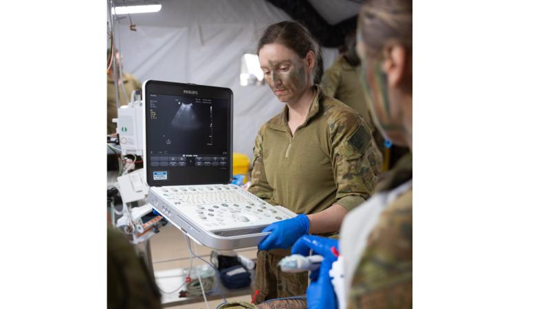 Australian Army radiographer Captain Hannah Wylie helps treat a simulated patient in the Role 2 Basic resuscitation bay during Exercise Rhino Run at Cultana Training Area.