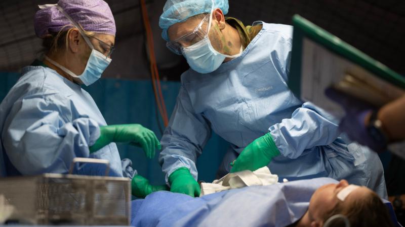 Australian Army officers Captain Guy Sheehan (right) and Lieutenant Svetlana Kolokolnikova perform and assist in the simulated surgery of a battle casualty in the Role 2 Basic surgical bay during Exercise Rhino Run at Cultana Training Area.