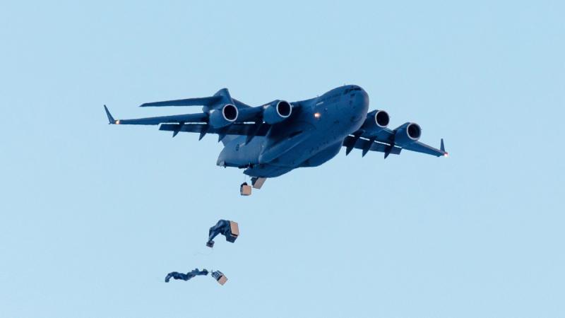 Palletised cargo descends under parachute from a C-17A Globemaster III to the sea ice drop zone near Mawson Research Station, Antarctica. 