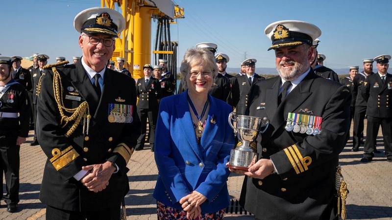 Commanding Officer of HMAS Rankin Commander Simon O’Hehir holds the Gloucester Cup, accompanied by Commander of the Australian Fleet Rear Admiral Chris Smith and Governor of South Australia Her Excellency the Honourable Frances Adamson.