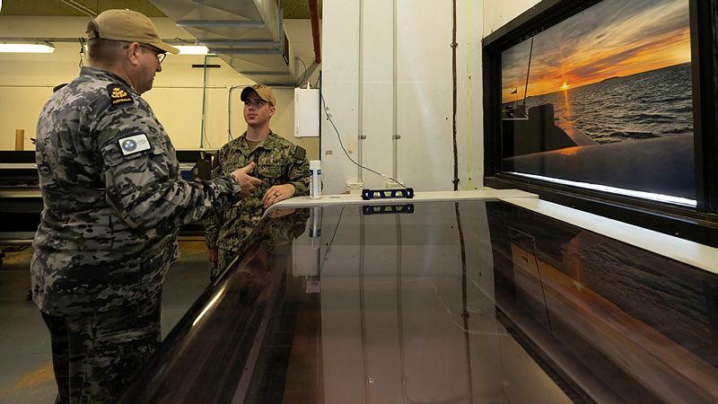 Petty Officer Darren Trewern speaks with a member of USS Emory S. Land during a tour of Fleet Support Unit – North during a port visit to Darwin. Photo: Petty Officer Leo Baumgartner