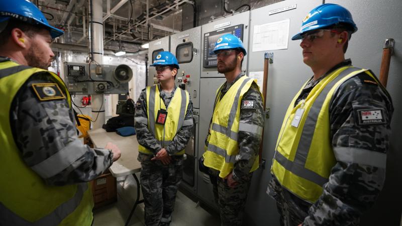 Apprentice technicians from the Technical Training Faculty are given a tour of technical infrastructure aboard HMAS Canberra as part of the new Navy apprentice technician experience tour.