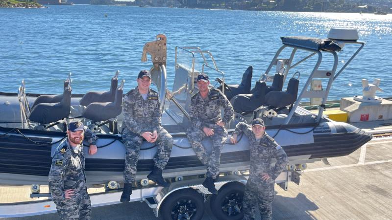 Sub-Lieutenant Nathan Rose, left, Seaman Riley Moreton, Able Seaman Justin Haynes and Seaman Jamie Jackson stand in front of a rigid hull inflatable boat at Fleet Base East after assisting a distressed kayaker in Sydney Harbour. 