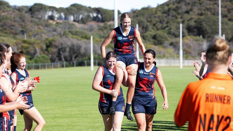 HMAS Stirling player Seaman Jess Edwards is carried off of the field in celebration of her 150th Australian Rules game. Photos: Petty Officer Craig Walton