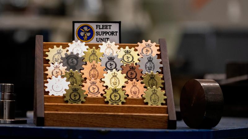 A display of Challenge Coins, designed and manufactured by members of the Royal Australian Navy Fleet Support Unit on-board USS Emory S. Land.