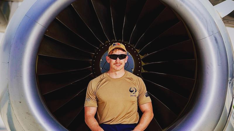 Air Force aircraft technician Leading Aircraftsman Andrew Fowler sits on the cowling of a E-7A Wedgetail during Operation Accordion at Australia's main operating base in the Middle East. 