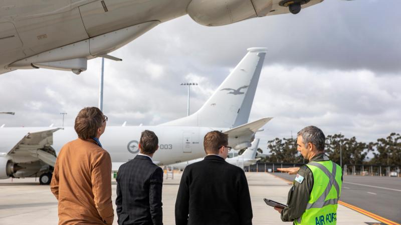 Squadron Leader Cosimo Panetta, right, highlights interesting aspects of the P-8A Poseidon aircraft during a visit by contractors Peter Ryder, left, Justin King and Adam Webber to RAAF Base Edinburgh, SA.