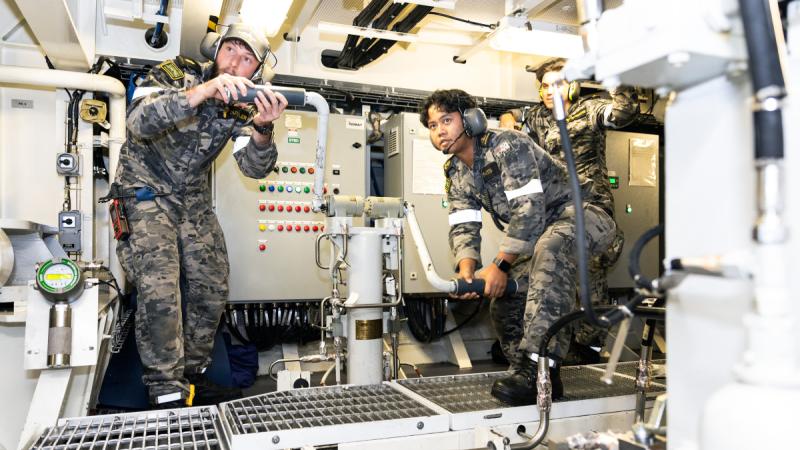 Marine technicians Able Seaman Damien Duthler (left) and Leading Seaman Noval Ipatidis conduct an engineering casualty control drill on HMAS Hobart as the ship sails through the Yellow Sea.