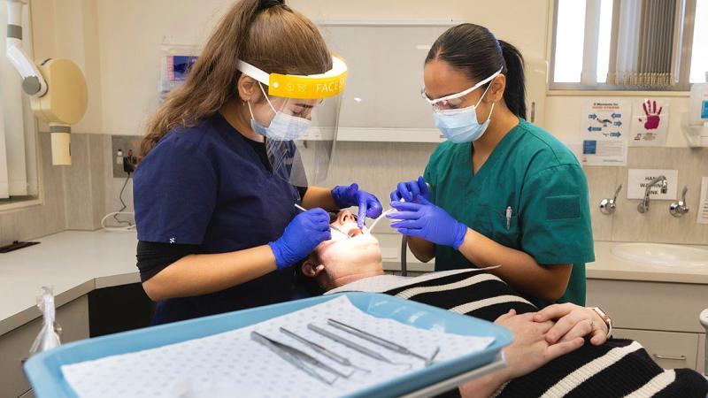 ADF dental assistant, Private Juliana De Veyra assists oral health therapist, Miss Athanasia Nikolakopoulos with cleaning procedure at Frankston Community Dental, Victoria. 
