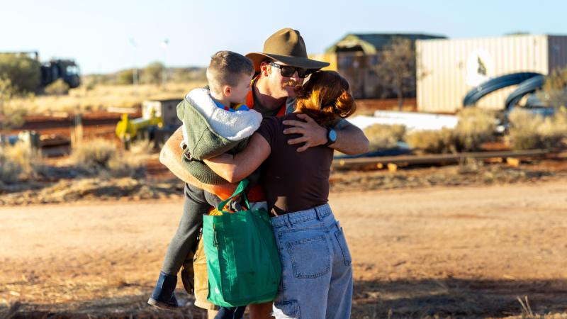 Australian Army soldier Sapper Benjamin Otto from 6th Engineer Support Regiment reunites with his son and partner during a family visit to the 2024 Army Aboriginal Community Assistance Programme in Amata, SA.