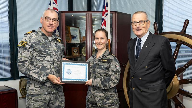 Commander Australian Fleet Rear Admiral Christopher Smith presents Able Seaman Emma Storey with an award for winning the 2023 Royal United Services Institute (RUSI) VIC Essay Competition at Fleet Headquarters, Sydney. Photo: Able Seaman Lucinda Allanson